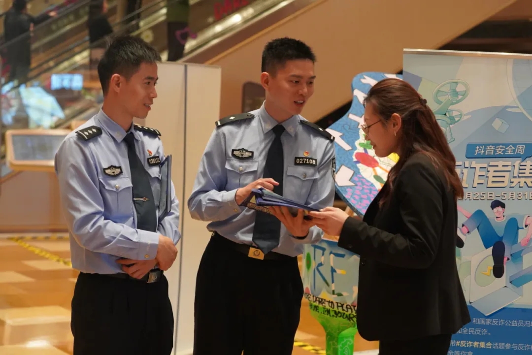 民警周世奇(中,马晓亮(左一)宣传反诈知识