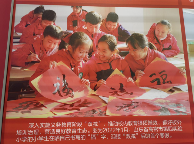 图为高密市第四小学的小学生在晒自己书写的“福”字。